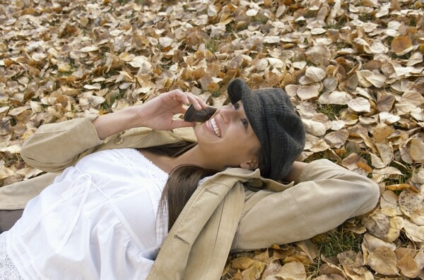 躺在在草地上接电话的美女图片