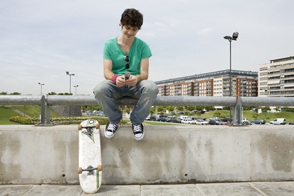 玩手机的滑板青年图片