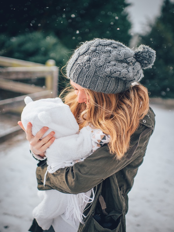 雪地里一位母親擁抱著孩子笑容滿面