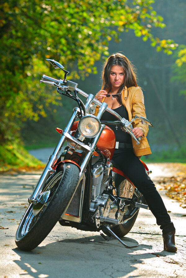骑在摩托车上手拿墨镜的美女图片