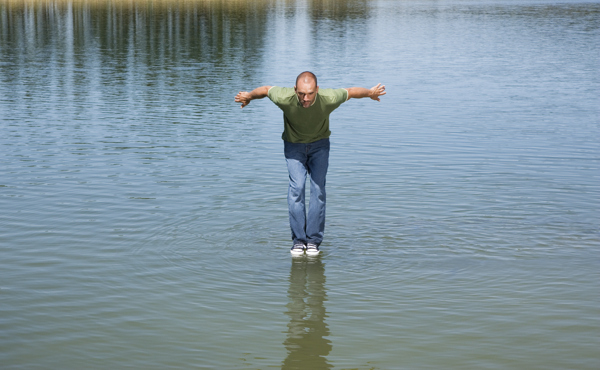 在水面上做跳跃动作的男人图片