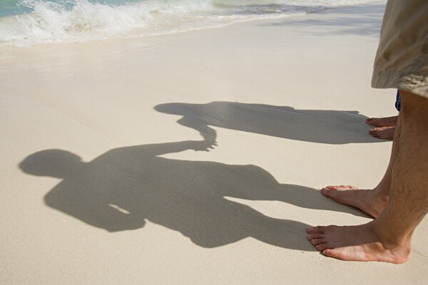 沙滩上牵手的情侣影子特写图片图片
