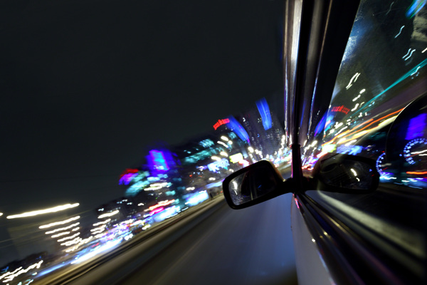 飞速行驶的汽车与城市夜景图片