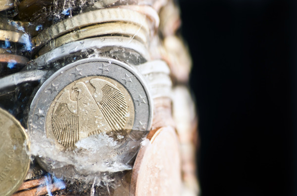 有光泽的欧元硬币冻结在冰前德国硬币