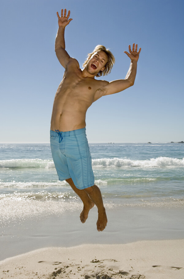 沙滩上跳跃的男人图片