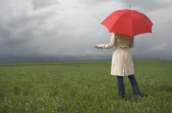 站在草地上打着伞的女人背影图片