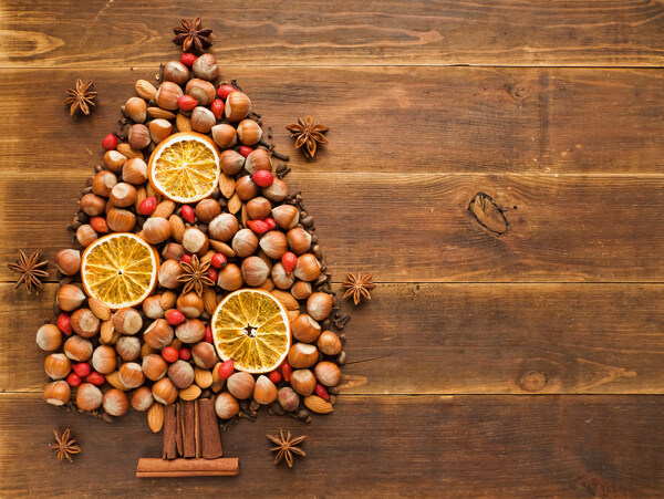 摆成圣诞树的坚果和柠檬片图片