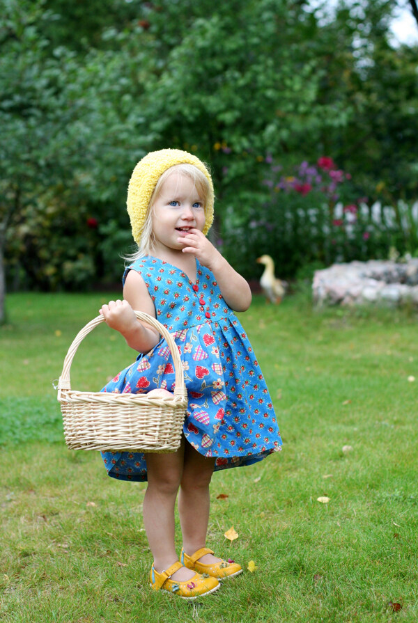 草地上提篮子的小女孩图片