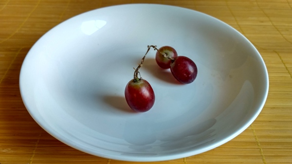 白色碟子上的三颗红葡萄